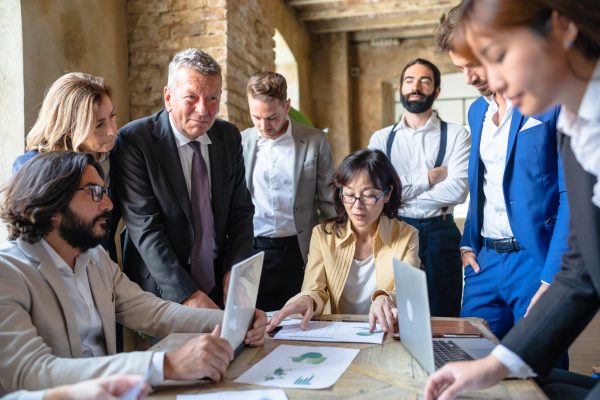 Multiracial business people sitting at the conference table while discussing about sustainable innovation strategy - Sustainability and pollution concept